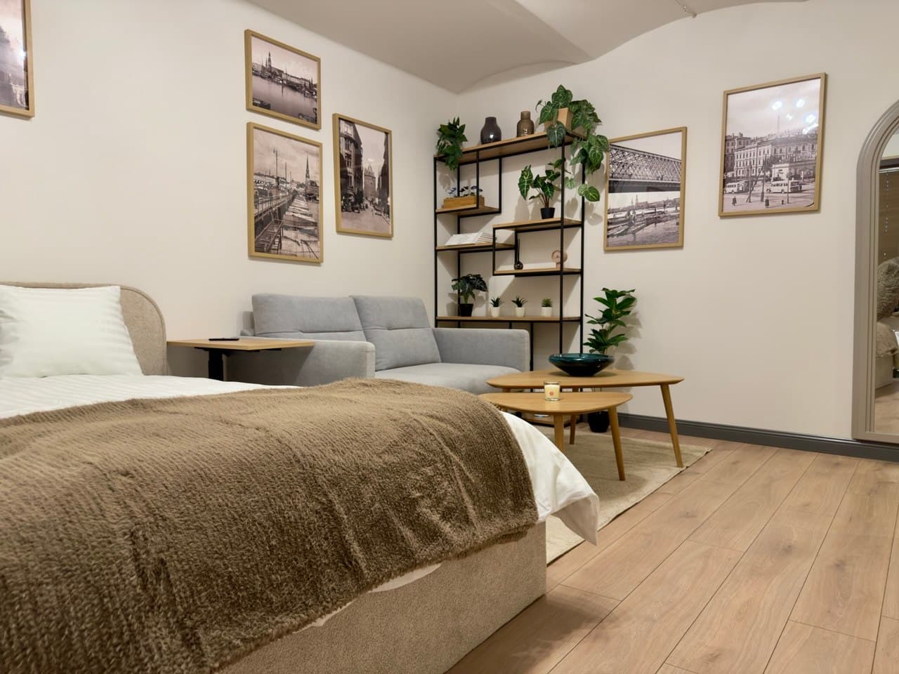Open-plan studio with kitchen, bed, sofa, and floral backsplash